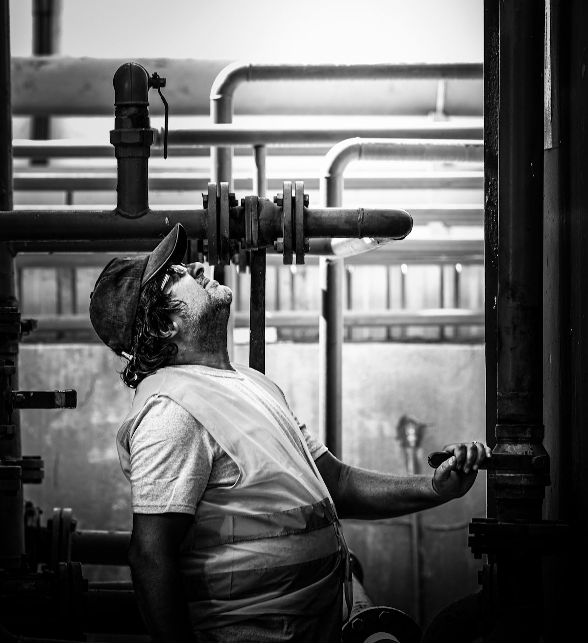 Technicien contrôlant les vannes et les tuyauteries d’un local technique